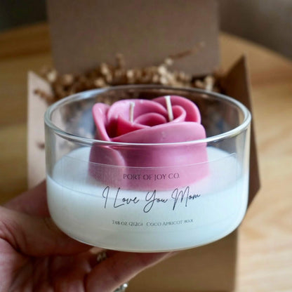 Candle gift for moms with pink rose design and 'I Love You Mom' text, held by a hand.