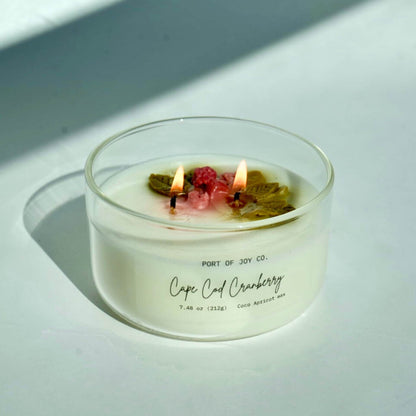 cranberry apple handmade candle lit in a white background