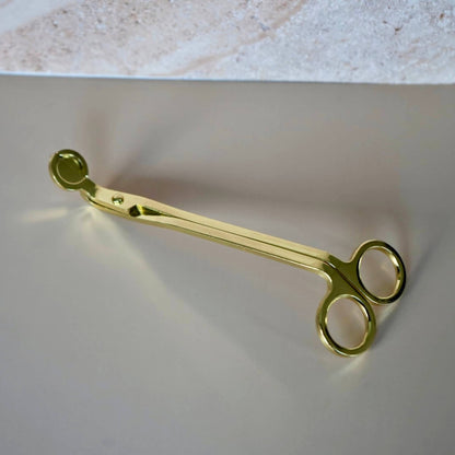 uxury gold wick trimmer candle accessory modern design on a pink background