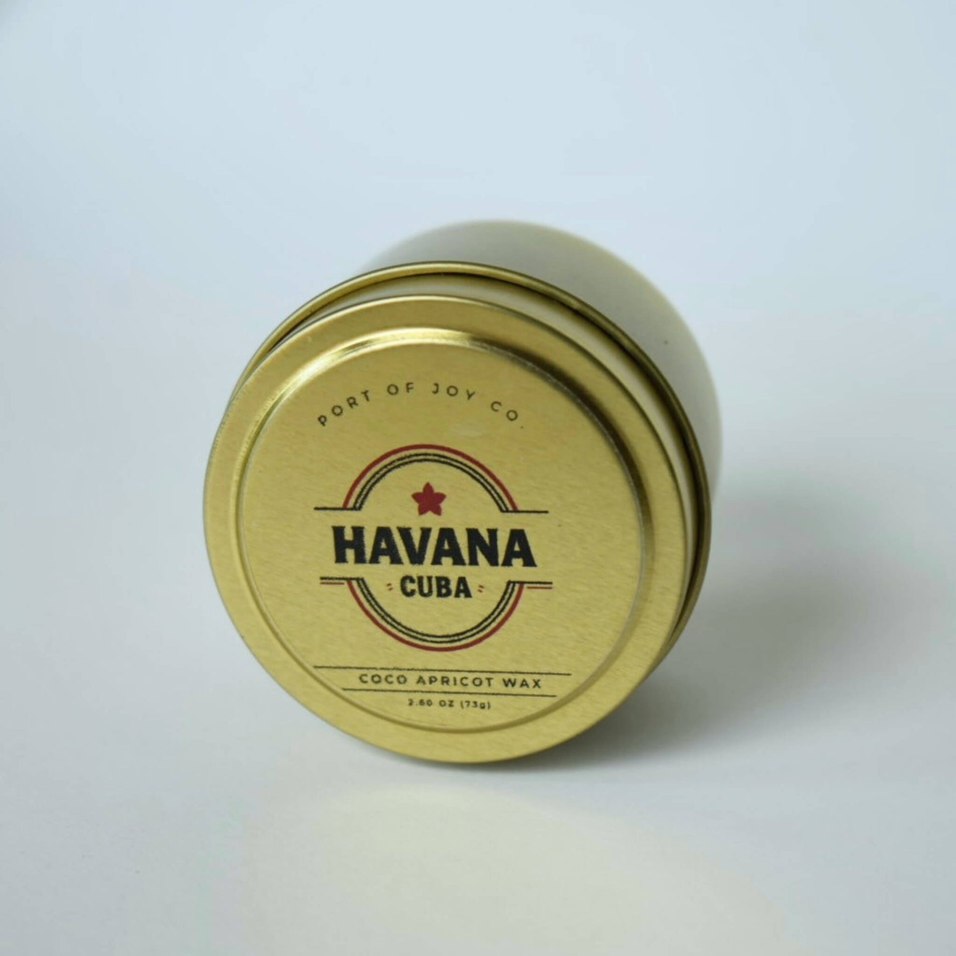 gold tin labeled 'Havana Cuba'. travel size candle for men