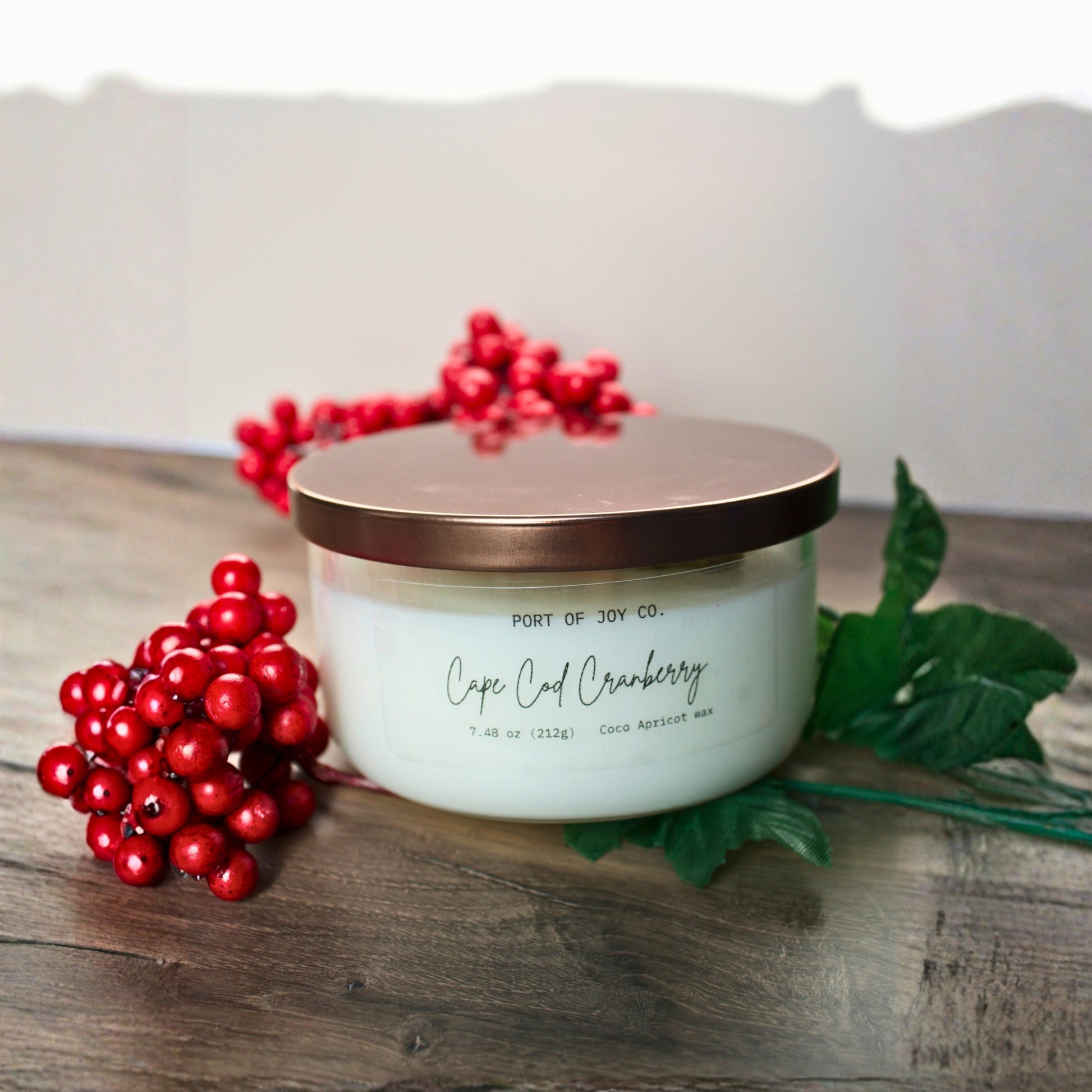 Hand poured Cape Cod Cranberry candle in minimalist clear glass jar with bronze lid, a luxurious eco-friendly holiday candle and thoughtful Christmas gift for women.