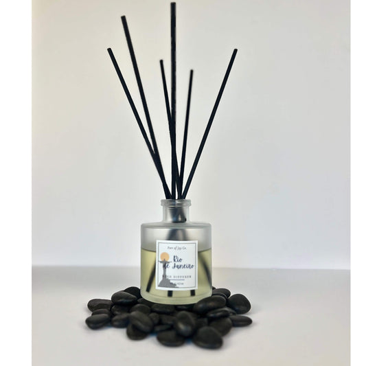 Reed diffuser with black sticks and a label on a white background