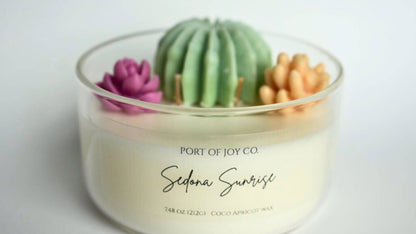 Candle with decorative cactus and succulents on a white background