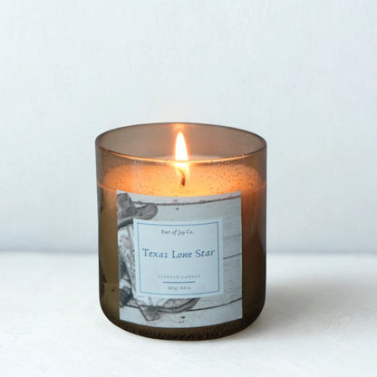 Candle in a brown glass jar with a label on a white background