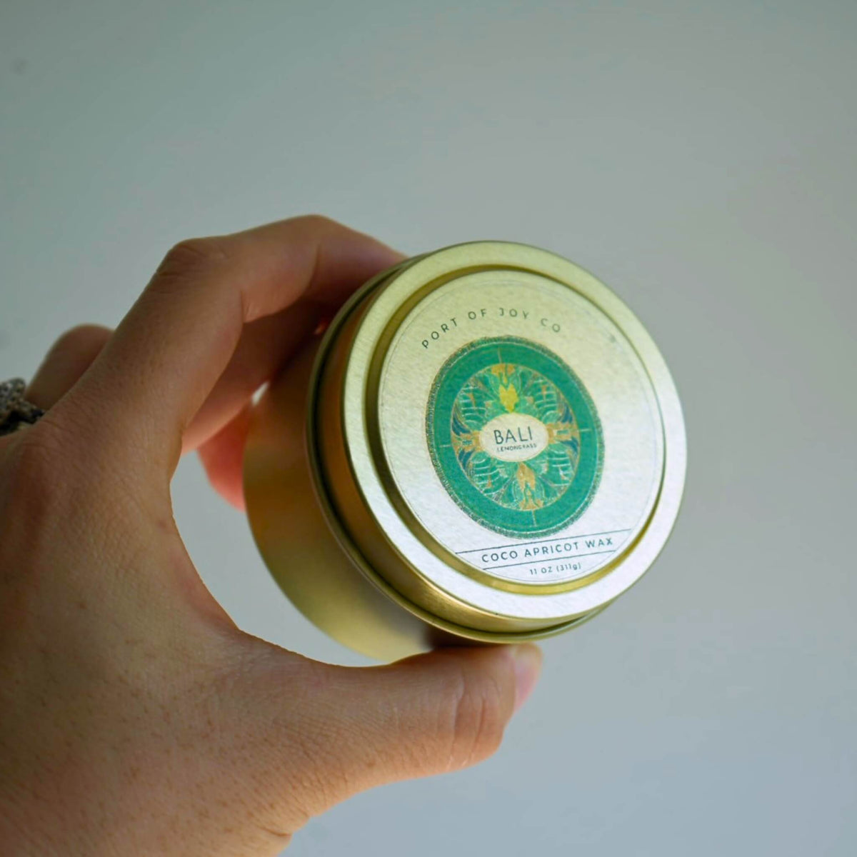 customer holding travel tin candle bali lemongrass & sage