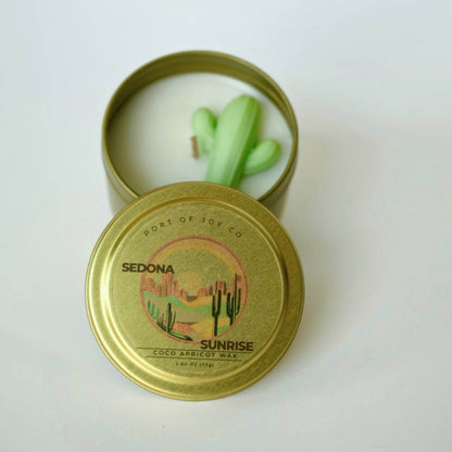 Candle in a gold tin with a cactus design on a white background