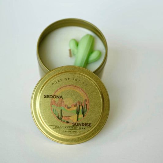 Candle in a gold tin with a cactus design on a white background