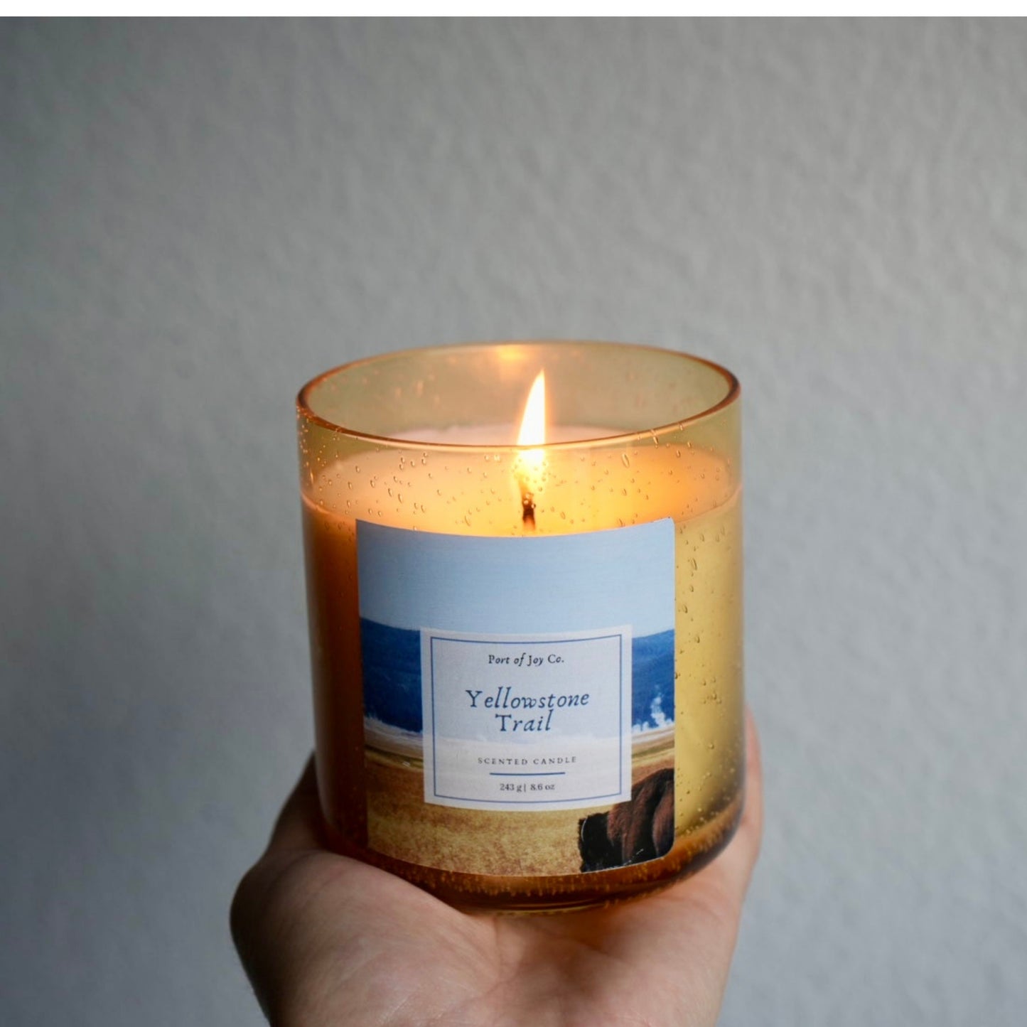 holding a candle. the candle is yellowstone trail 