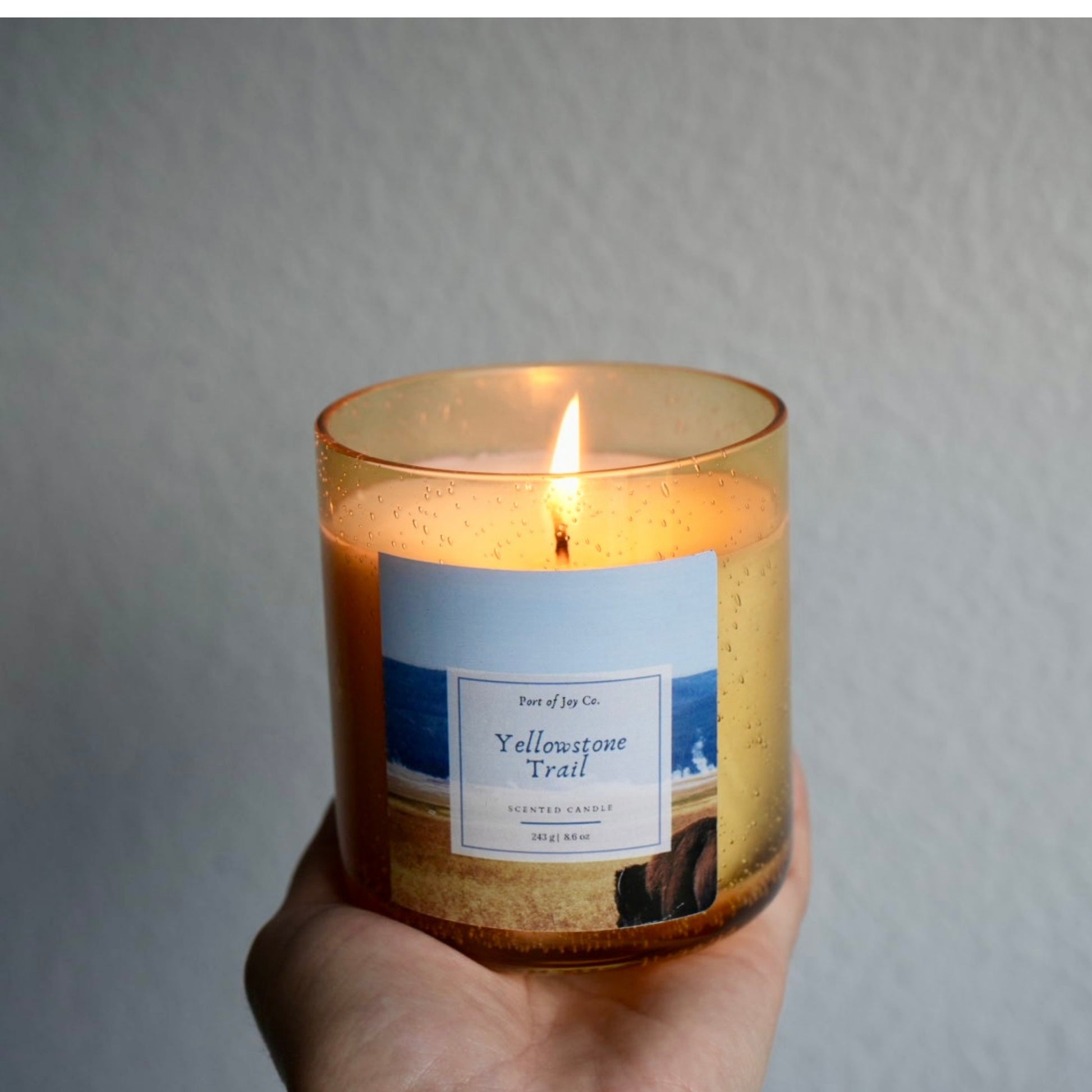 holding a candle. the candle is yellowstone trail 